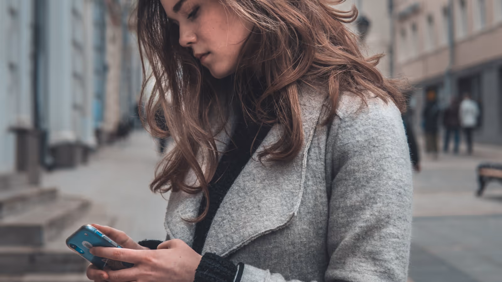 Une prof de yoga consulte son téléphone dans son espace de pratique, à la recherche de nouvelles élèves près de chez elle