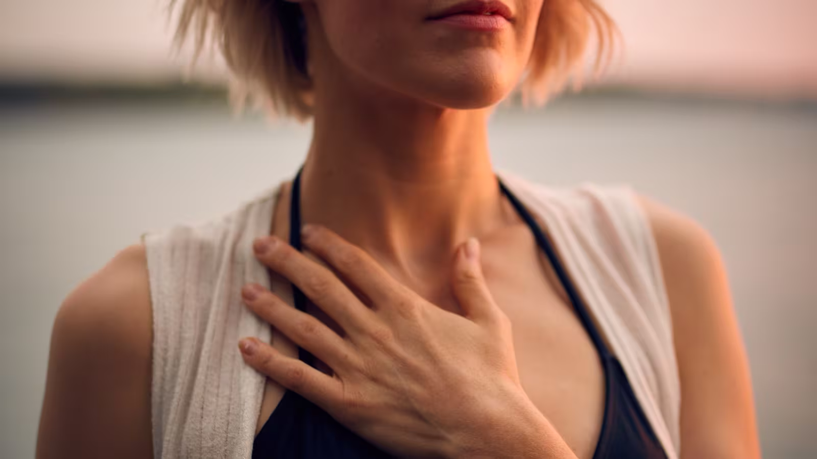 Personne assise en tailleur, yeux fermés, mains posées sur le ventre pendant un exercice de respiration