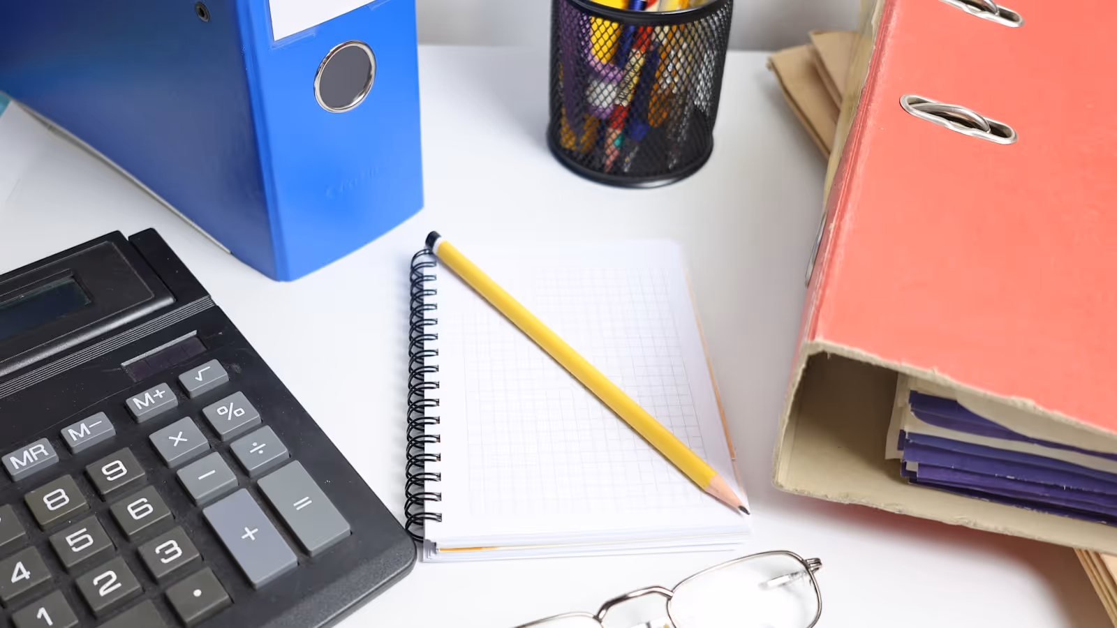 Une prof de yoga assise à une table, un carnet et un téléphone devant elle, en train de faire le point sur son administratif
